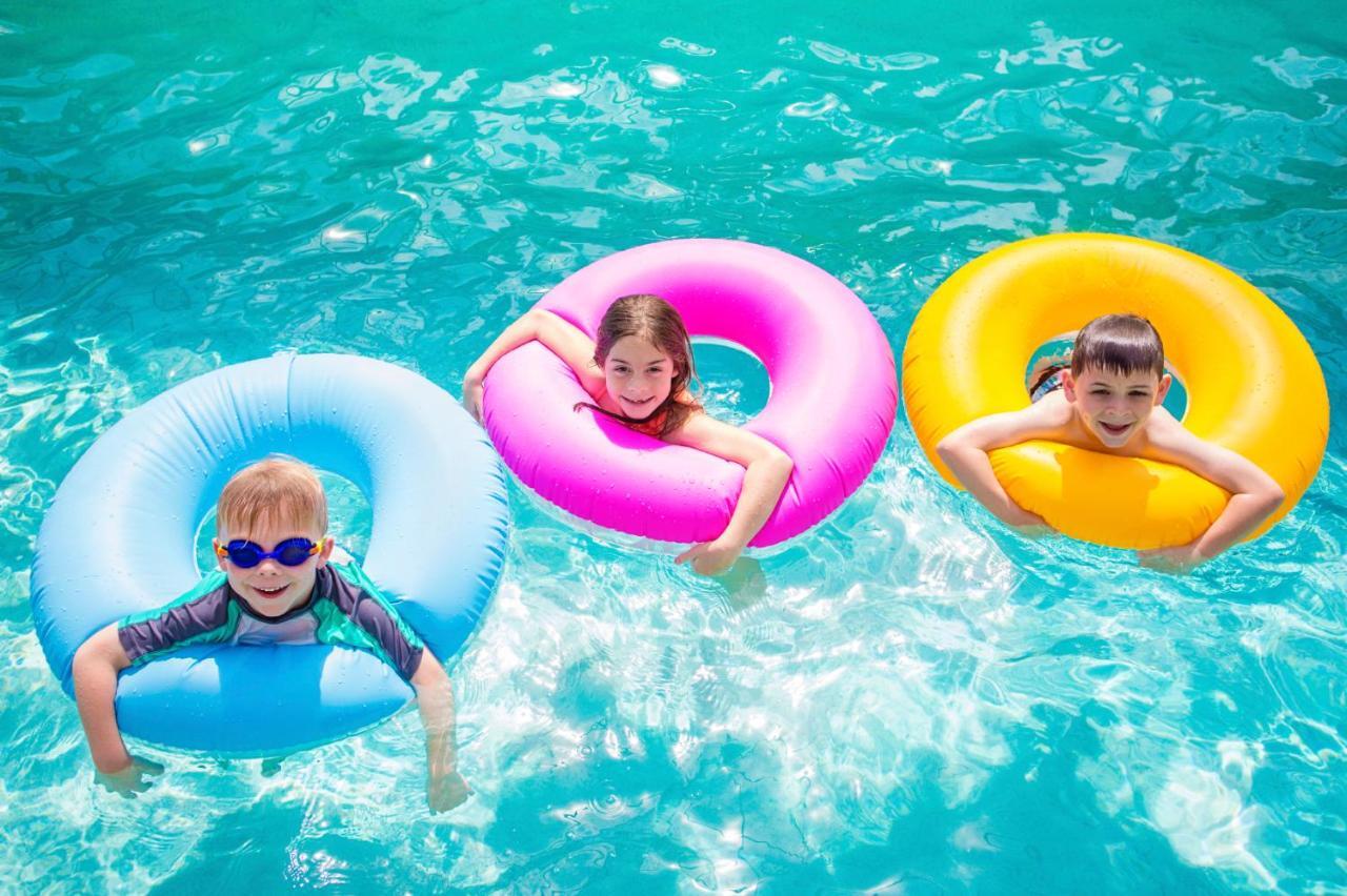 ザ アクト ホテル シャールジャ シャルジャ エクステリア 写真 Children using inner tubes in a swimming pool